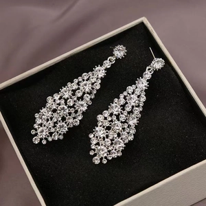 Macro view of silver dangling earrings with sparkling crystals in a black velvet jewelry box