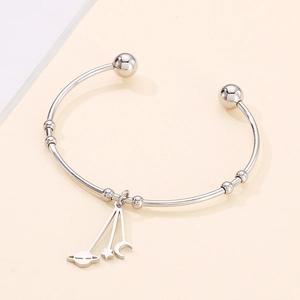 Detailed view of silver titanium steel open bangle with star and moon charms