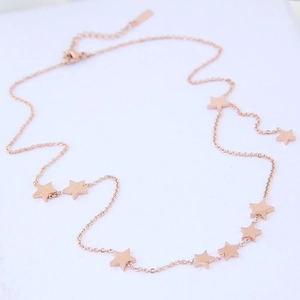Detail view of rose gold titanium steel necklace featuring star charms and lobster clasp