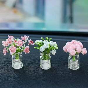 Close-up of three luminous artificial gypsophila flower glass vases with luck labels