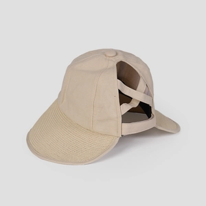 Detail of light beige ponytail cap showing the criss-cross elastic bands and woven texture