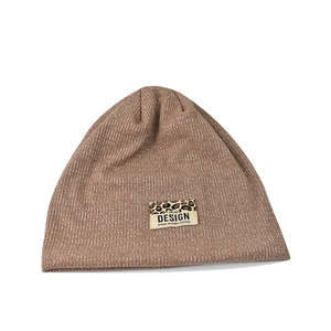 Khaki knit beanie with a leopard print patch and minimalist design text for women