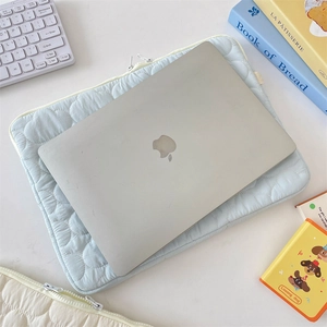 Detail of light blue cloud-quilted laptop sleeve with white dual zippers and soft padding