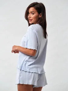 Detail of light blue waffle knit pajama set featuring lettuce edge hems on sleeves and shorts