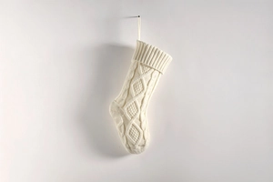 Close-up of cream white cable knit Christmas stocking showing detailed woven texture