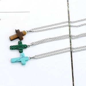 Three natural stone cross pendants in tiger eye, malachite, and turquoise on silver chains