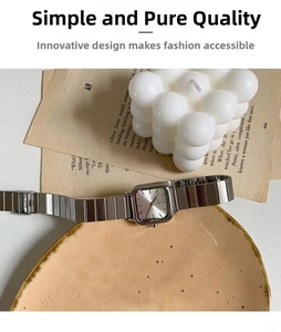 Detail shot of a minimalist silver square quartz watch with a sleek metal chain bracelet