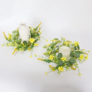 Close-up of yellow daisy and eucalyptus candle rings with realistic fabric textures