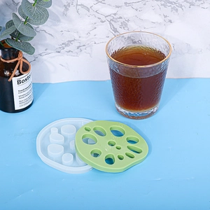 Detail of lotus root silicone mold with finished green resin coaster on a styled surface