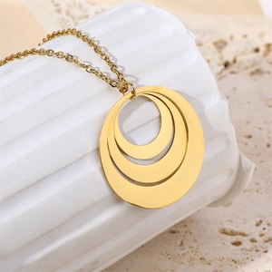 Close-up of triple-layered 18k gold interlocking circle pendant on a minimalist necklace