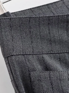 Détail du tissu à rayures gris foncé montrant la texture et la couture de la taille