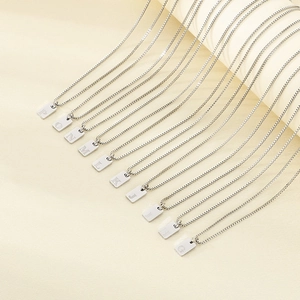 Detailed row of silver alphabet box chain pendants from P to G in polished steel