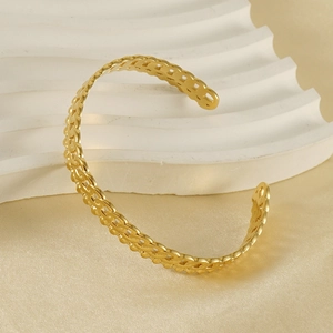 Détail du bracelet jonc ajouré en acier inoxydable doré 18K sur soie