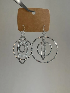Detail of silver layered hollow hoop earrings with textured finish and circular design