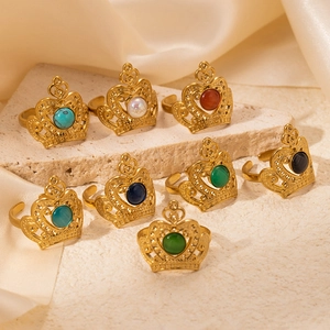 Elegant gold crown rings with colorful stones set on vintage stone and silk display