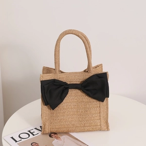 Sweet woven straw handbag with large black bow and khaki texture for beach vacation