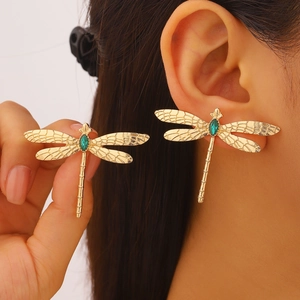 Vue détaillée d'une boucle d'oreille libellule avec pierre verte et ailes dorées fines