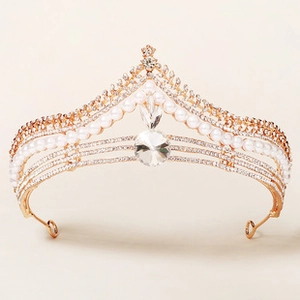 Detailed view of luxury bridal crown with gold alloy finish, rhinestones and elegant pearls
