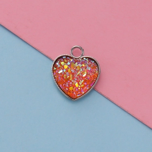 Close-up of 13mm heart-shaped stainless steel pendant with orange glitter resin inlay