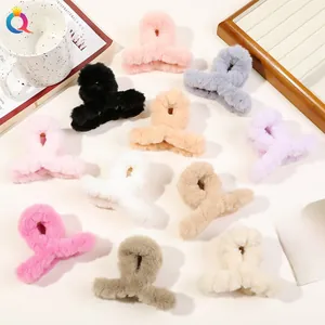 Various colors of plush large hair claws displayed with cozy home decor props