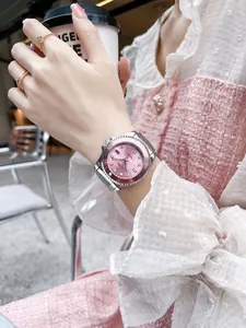 Nahaufnahme der Uhr mit rosa Zifferblatt und Stahlarmband im Café-Ambiente