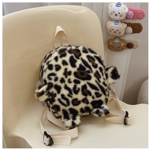 Detailed plush texture of leopard print toddler backpack with cute bear ears on chair