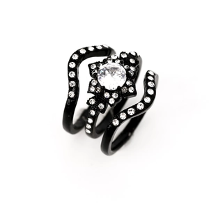 Macro view of black plated three-piece wedding ring set with zircon floral center