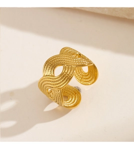 Detailed view of wave-textured golden stainless steel ring with woven design