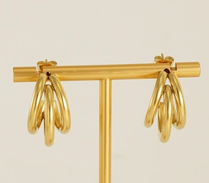 Detailed view of 18K gold plated triple hoop stud earrings on a T-bar jewelry display