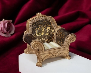 Detailed view of vintage gold sofa-shaped ring holder with baroque carvings and velvet slots