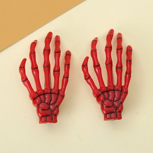 Detailed close-up of a pair of bright red skeleton hand hair clips for Halloween parties