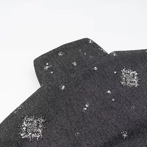 Dettaglio del colletto in lana grigio scuro con ricami di paillettes e perline a fiocco di neve