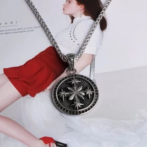 Macro view of vintage silver steel chain necklace with starburst embossed round pendant
