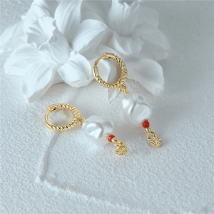 Detail of S925 silver twist hoop earrings with baroque pearls and gold star pendants