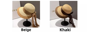 Detail view of woven straw sun hats in beige and khaki with elegant silk ribbons