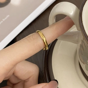 Close-up of minimalist 18K gold-plated star and moon stackable ring on finger