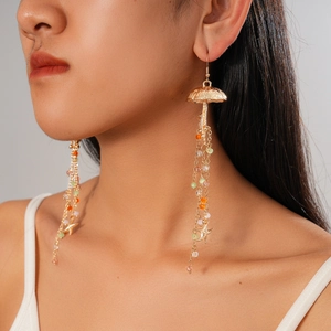 Close-up of gold jellyfish earrings with colorful glass beads and starfish tassels on a model