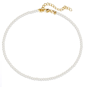 Macro detail of round faux pearl necklace with adjustable gold lobster clasp and chain