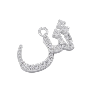 Macro view of silver Arabic Allah pendant with clear gemstones on a white background