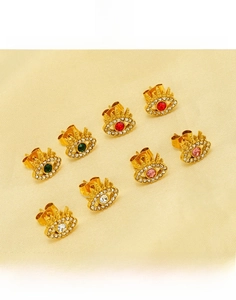 Macro detail of gold plated evil eye stud earrings with colorful zircon stones
