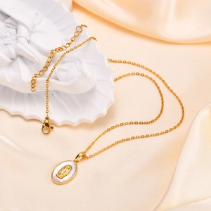 Detail of gold oval Virgin Mary pendant necklace with lobster clasp on white silk