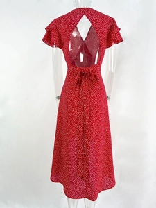 Detail view of red polka dot dress featuring back cutout and elegant waist tie bow