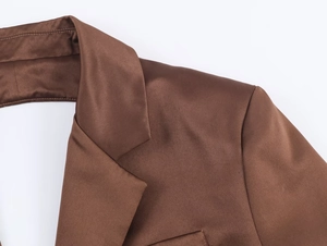 Gros plan du col et de l'épaule d'un blazer en satin marron au fini soyeux chic