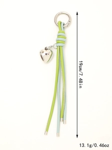 Detail of woven keychain with heart pendant and tassels in green and blue colors