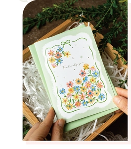 3D daisy flower pop-up card with green envelope held over a decorative wooden gift box