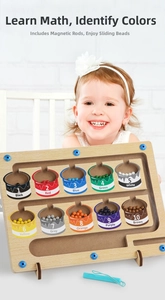Close-up of a child using a magnetic pen to move colorful beads in a wooden maze toy