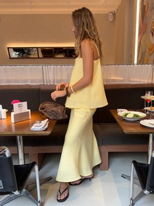 Detail of pale yellow linen two-piece set featuring a camisole top and wide-leg trousers