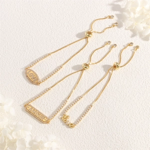 Detailed close-up of golden adjustable bracelets with LOVE and AMOUR engraved charms