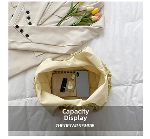 Macro view of cream pleated tote bag interior showing spacious storage for daily essentials