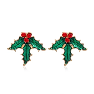 Détail de boucles d'oreilles houx de Noël avec émail vert et baies en cristal rouge